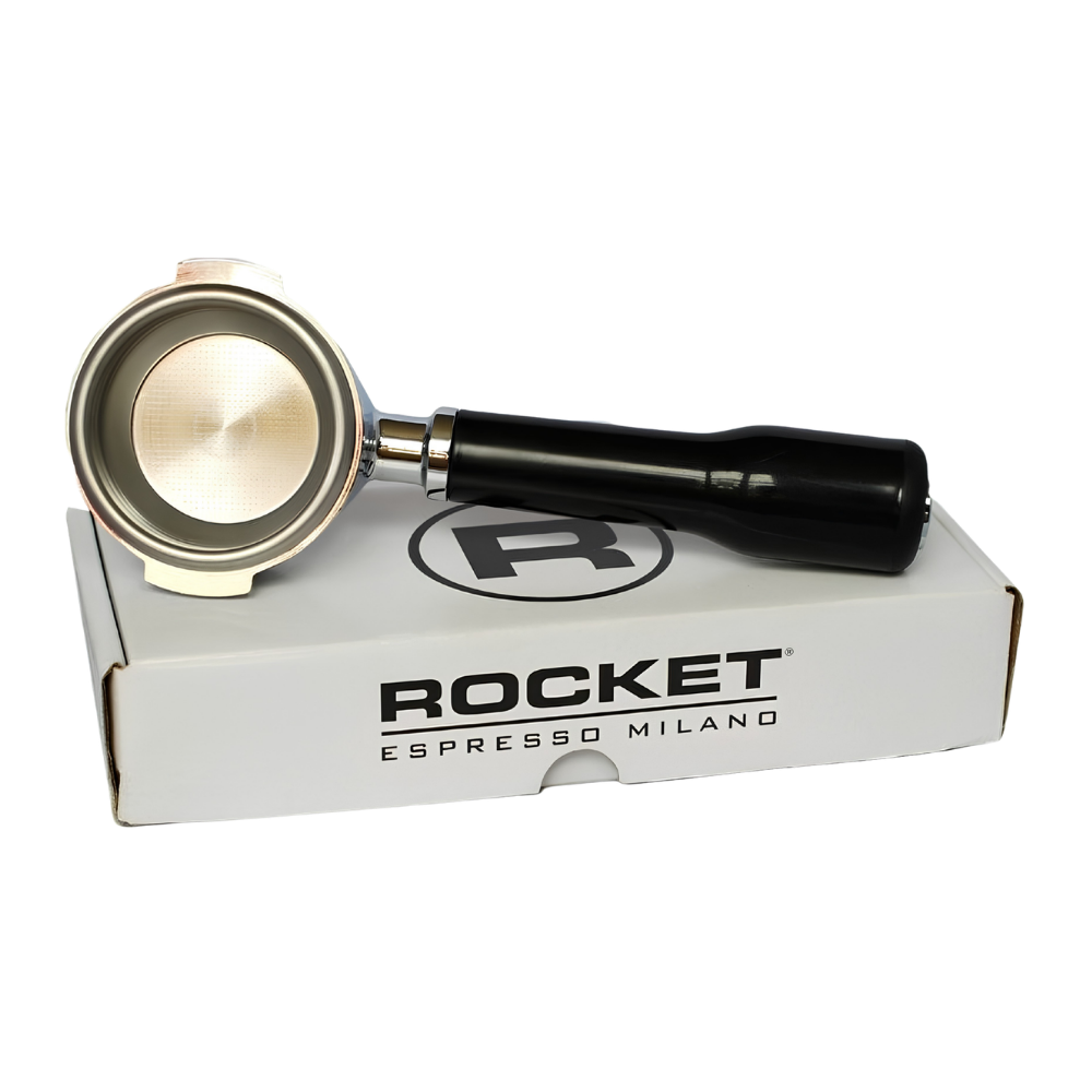 A Rocket Espresso Milano portafilter with a black handle and stainless steel bowl, resting on top of its white branded cardboard packaging box against a white background.